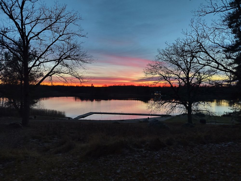 Ännu en bild av sjön (men lite annan vinkel). Klockan är en halvtimme senare så himmeln är mörkare nu och solnedgången är mer en röd strimma vid horisonten.