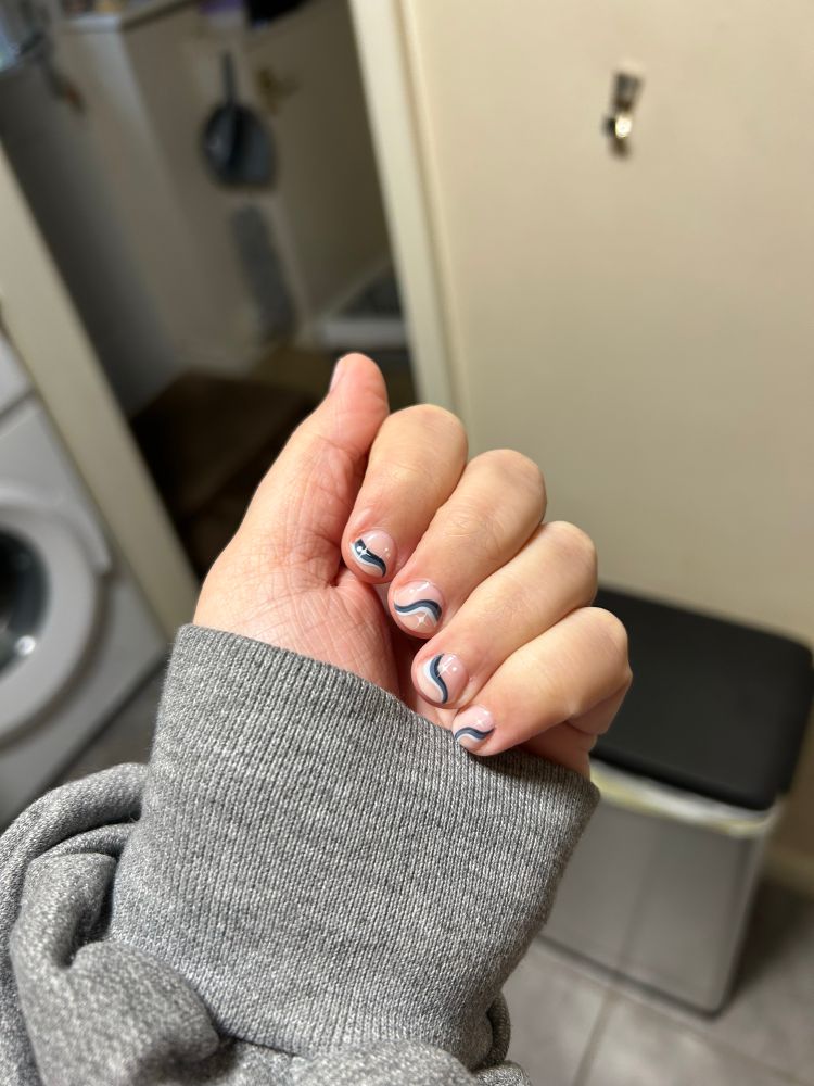 short nails with wavy lines in different shades of blue and white stars