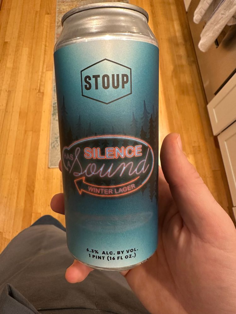 Beautifully designed beer can with pseudo neo “Silence has a sound” label and dark misty fir trees over (presumably) a dark misty sound. 
