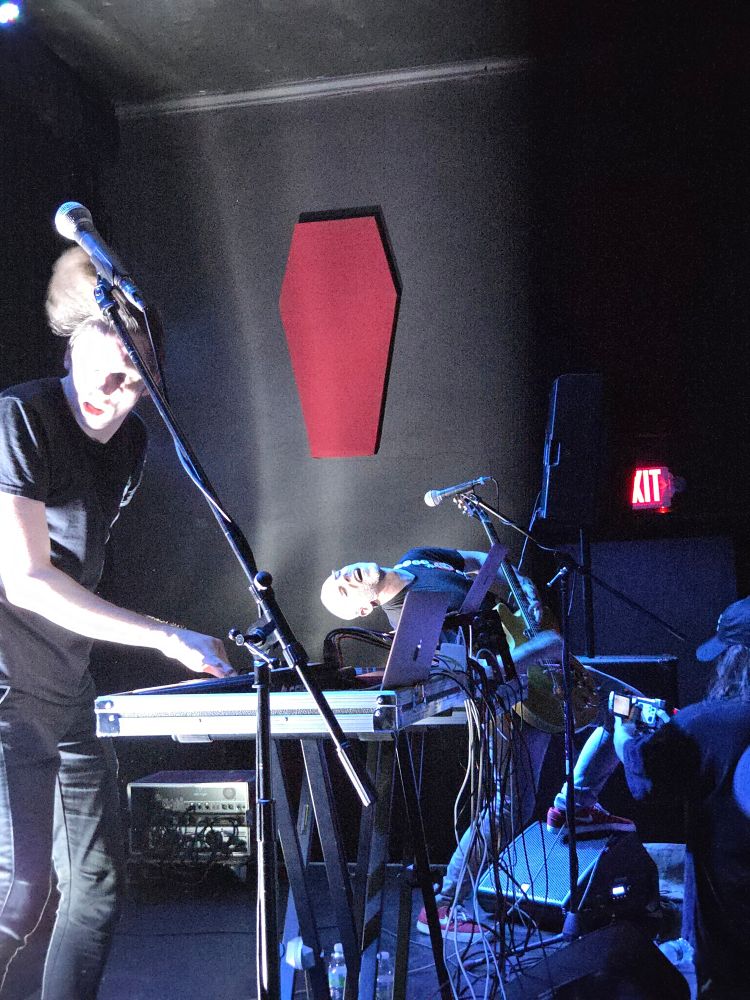 Image is of James Webster wailing on guitar while Tech Honors dances around