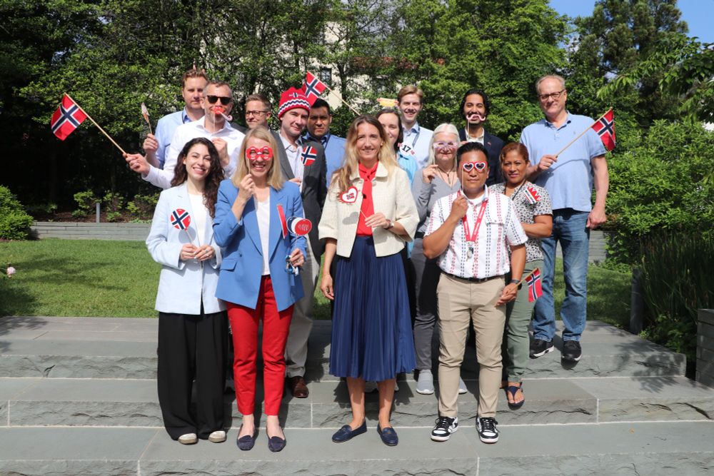 Embassy staff pose with Norwegian flags for Syttende Mai.