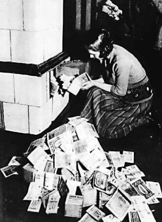 Young woman burning cash notes during hyperinflation in Weimar Germany.