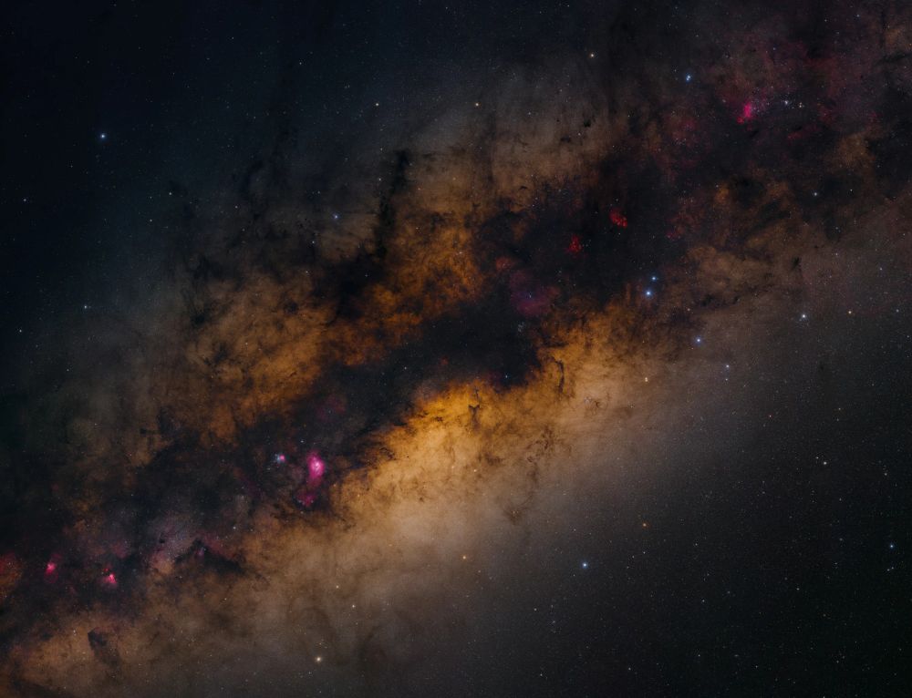 A view of the Milky Way, our home galaxy, from our little corner near the outer edge. A band of dark, nebulous swirls seen against the backdrop of radiant, nebulous swirls, spotted with nebulous swirls of various frequencies, as gas and dust collect into stars, burst with new elements, and repeat.