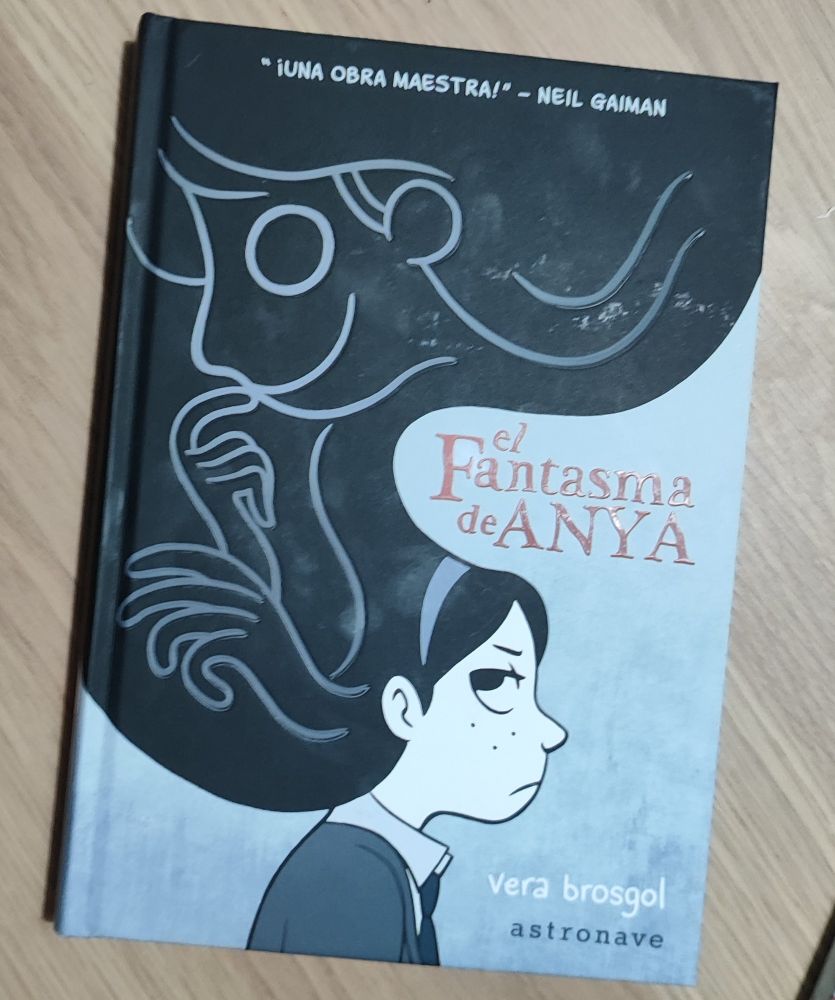 Portada de la novela. Colores grisáceos con el título en rojo. Aparte Anya de perfil y el fantasma en su pelo ocupando la parte superior de la portada