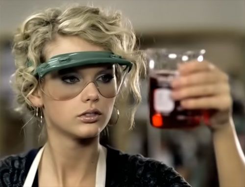 Taylor Swift holds a beaker, from her "Teardrops on My Guitar" video. I got this picture from labsafety.org. Taylor is wearing safety goggles.