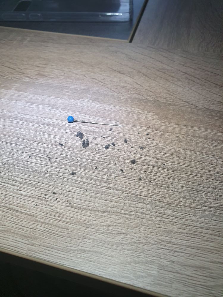 Une aiguille avec les déchets de poussière et saleté sortis du port USB de mon téléphone