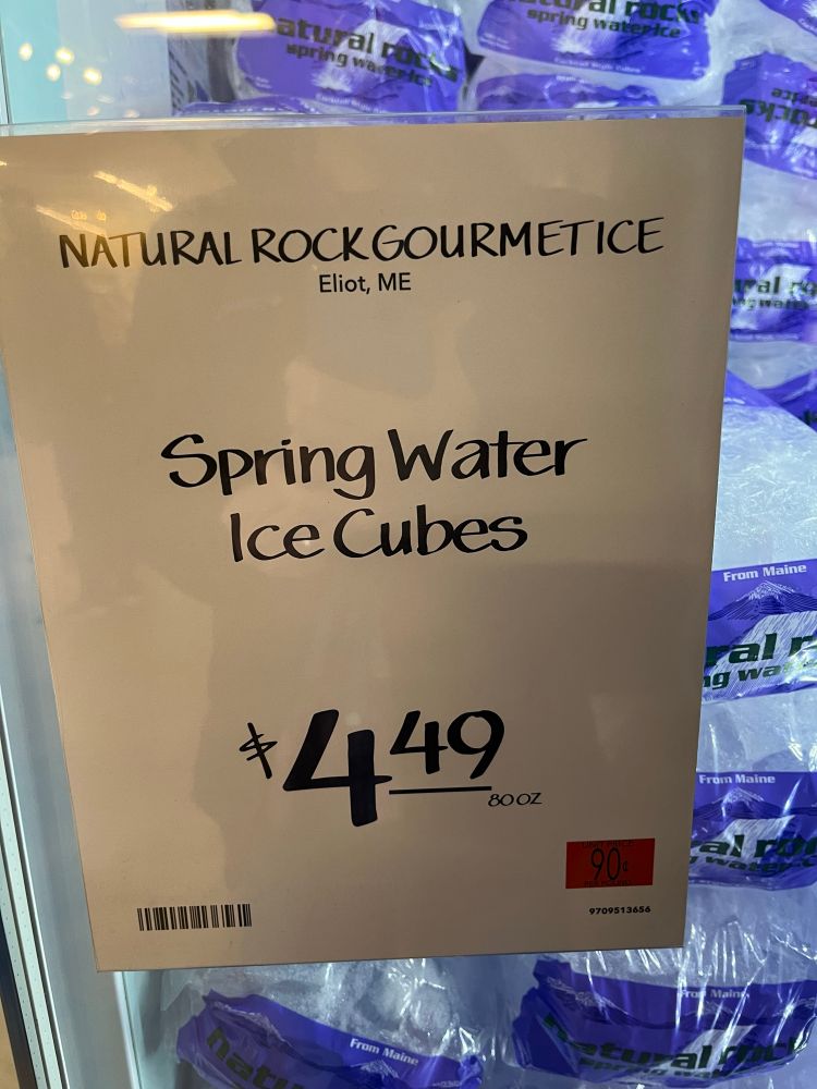 A freezer full of ice bags for sale with a sign that says natural rock, gourmet ice, Eliot, Maine, $4.49