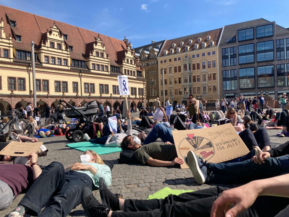 Mehrere hundert Menschen liegen auf dem Leipziger Marktplatz stellevertretend für ME/CFS Betroffene