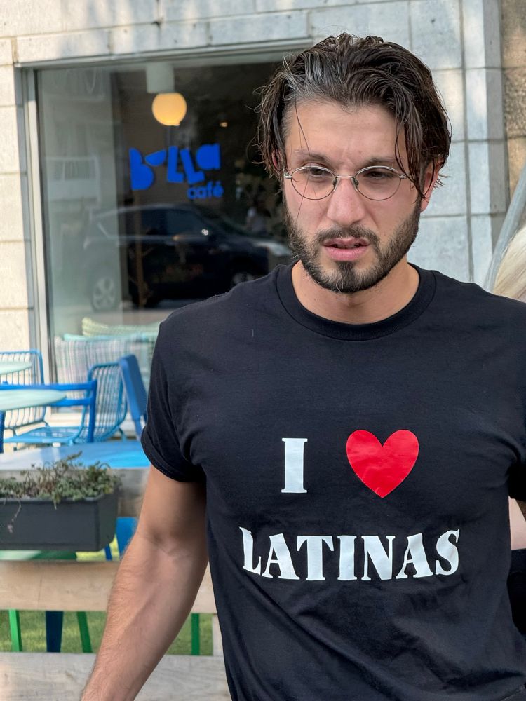 bbno$ in a black shirt that reads “i heart latinas” except the in place of the word “heart” it’s a red heart.