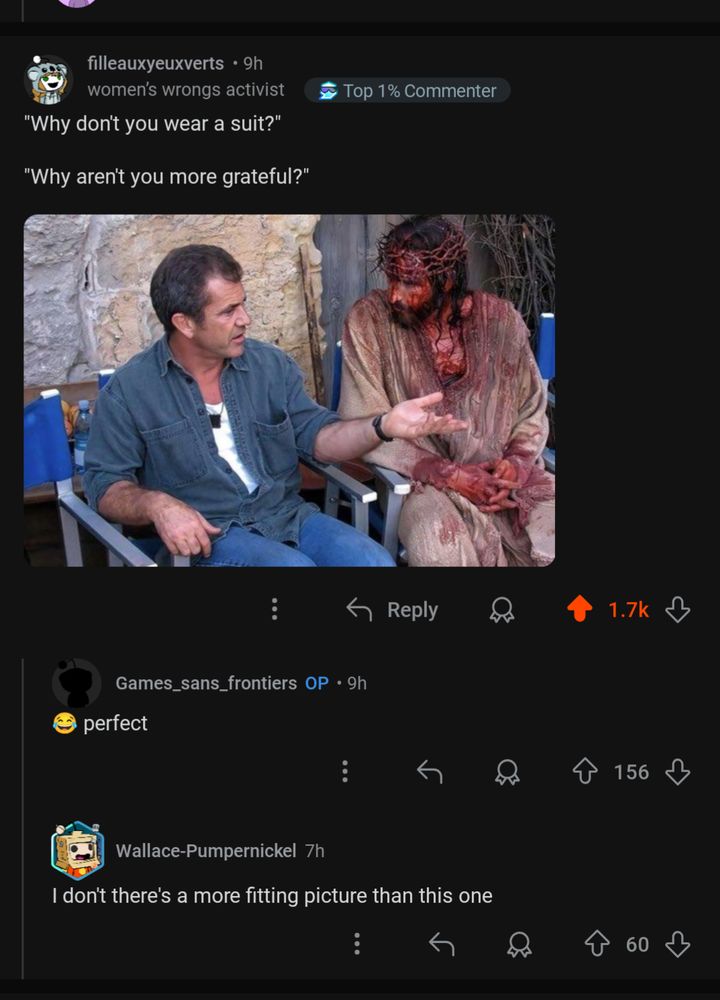 Mel Gibson and Jim Caviezel sitting in directors' chairs while shooting Last Temptation of Christ. Mel is explaining something to Jim. Jim listens, in full Jesus-on-the-cross drag, including crown of thorns and blood-soaked head, face, linen-clad body, and hands.