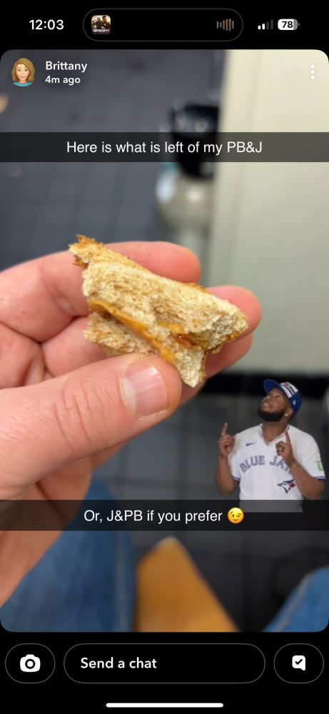 A hand holding the last bit of a PB&J sandwich with a note that says “here is what is left of my PB&J or, J&PB if you prefer” with a picture of Vladdy pointing up at it
