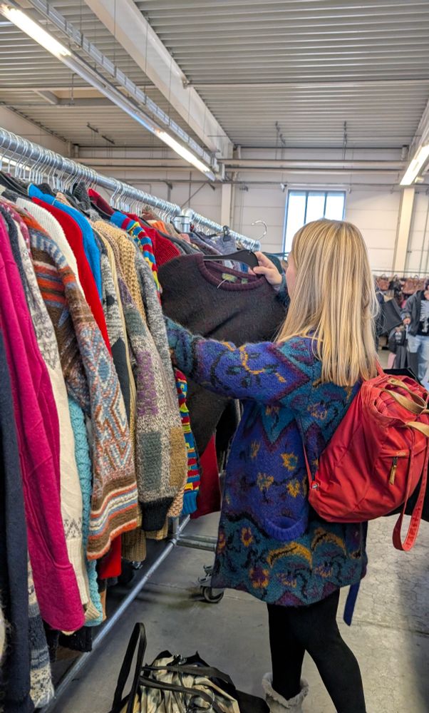 A person scanning through clothing racks