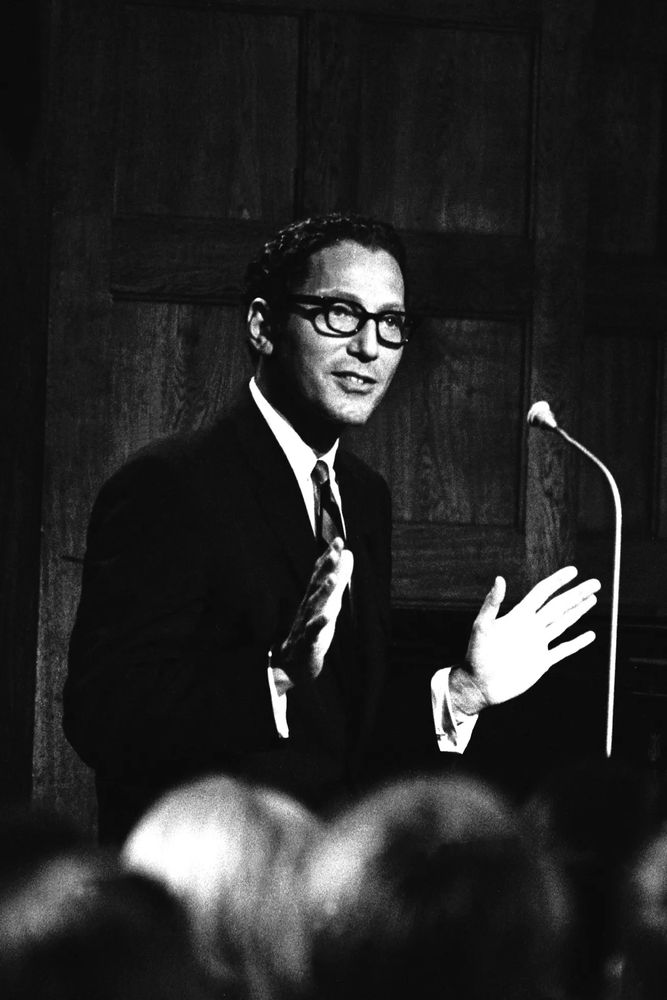 Tom Lehrer in black and white photo in front of an audience. #AcademicSky #Musicsky #ScienceCommunication #ResearchIntegrity