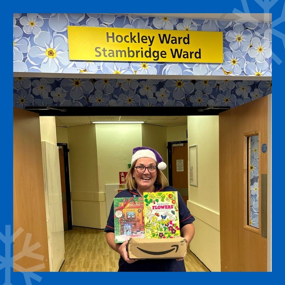 Helen, ward manager of Hockley and Stambridge ward stood out side the ward holding presents with a purple and white santa hat.
