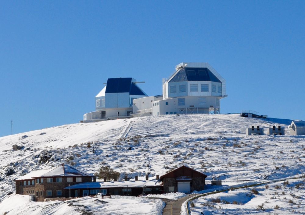 The twin Magellan telescopes on a snowy mountaintop.