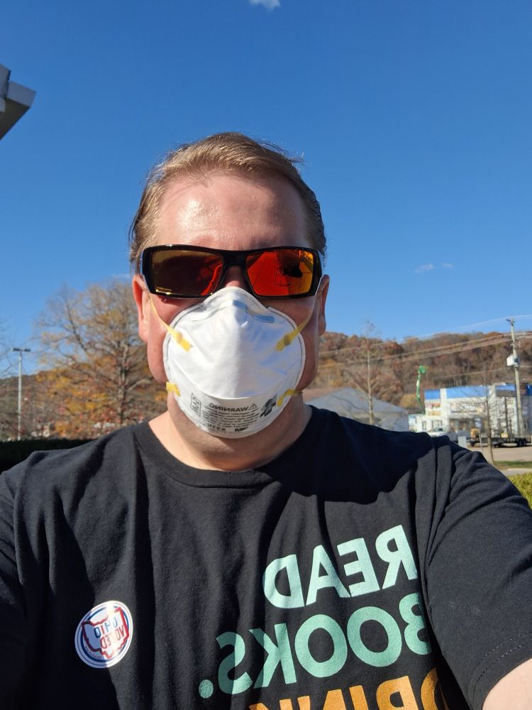 Me outside my polling place wearing a T-shirt reading "READ BOOKS.  DRINK COFFEE.  FIGHT EVIL." and with my "I Voted!" sticker. 