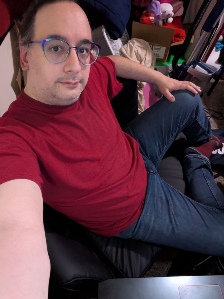 Me, lounging in my new chair.  One arm of the chair is bent, allowing me to stretch my leg out and sit reclined.