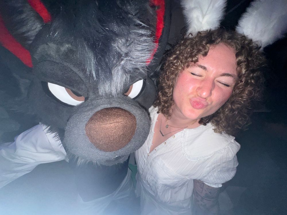 Riley dressed as Haru making a kissy face with Dac as Legoshi