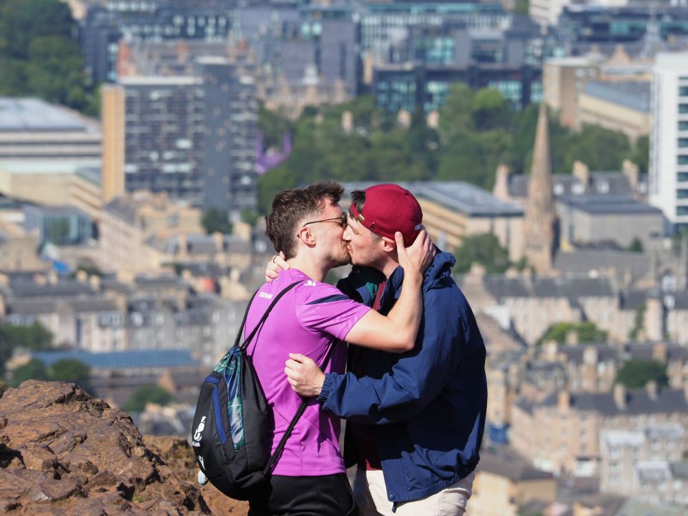 Me and my fiance embracing for a kiss at the top of Arthur's Seat in Edinburgh 