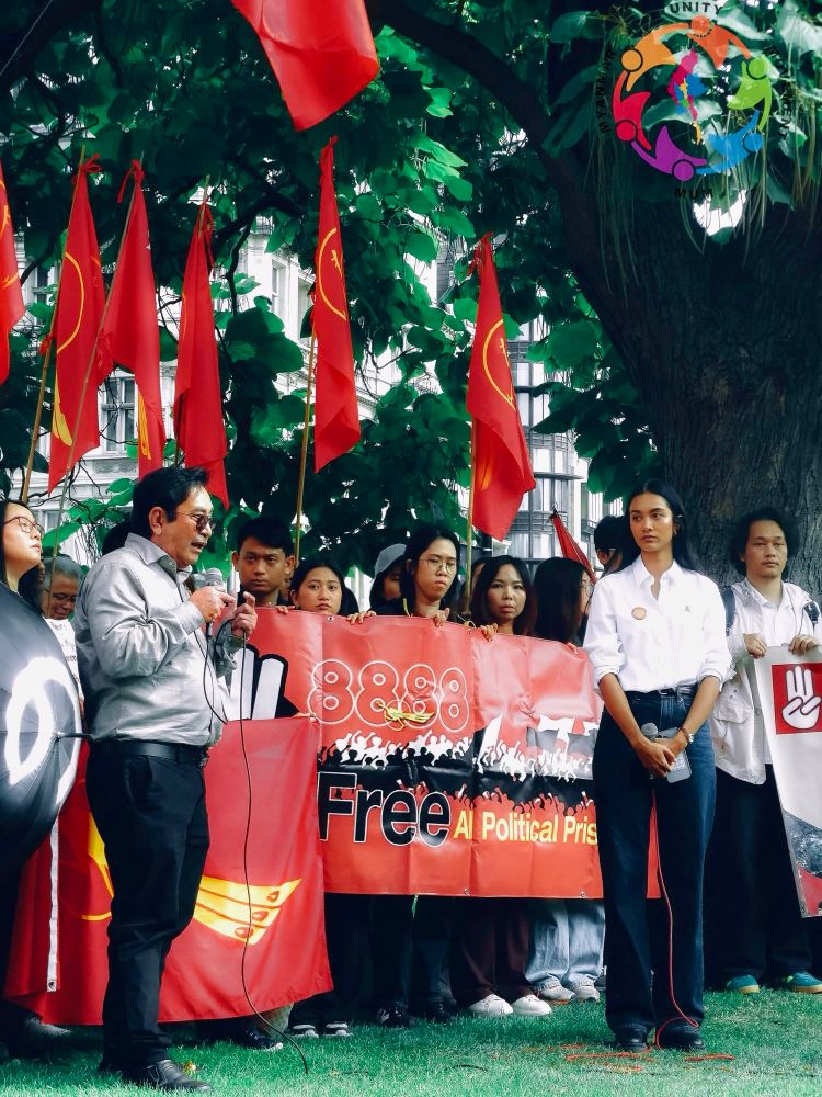 U Maung Maung Aung, NUG MOFA UK Representative (basically an ambassador for the National Unity Government, Myanmar’s exiled civilian government) and model/activist May Myat Noe speaking at the anniversary protest today. There are people behind them with more red NLD flags and a red banner that says ‘8888 Free All Political Prisoners’.

Photo Credit: Min Khant Ko Ko / Myanmar Unity Movement 