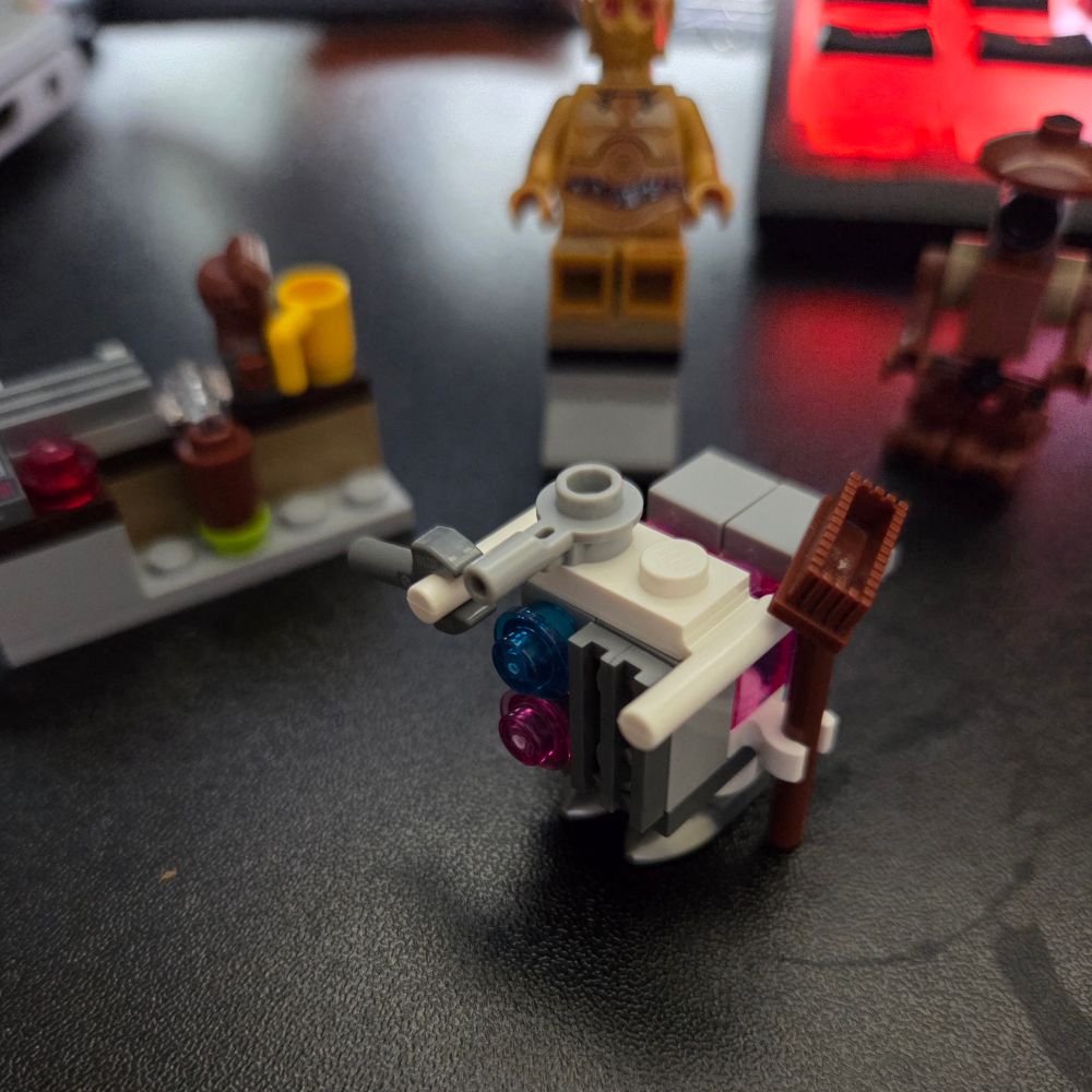 Star Wars LEGO, close up of growing LEGO pieces from advent calendar. In the middle is a white and grey janitor style robot with a broom and spoon attached.