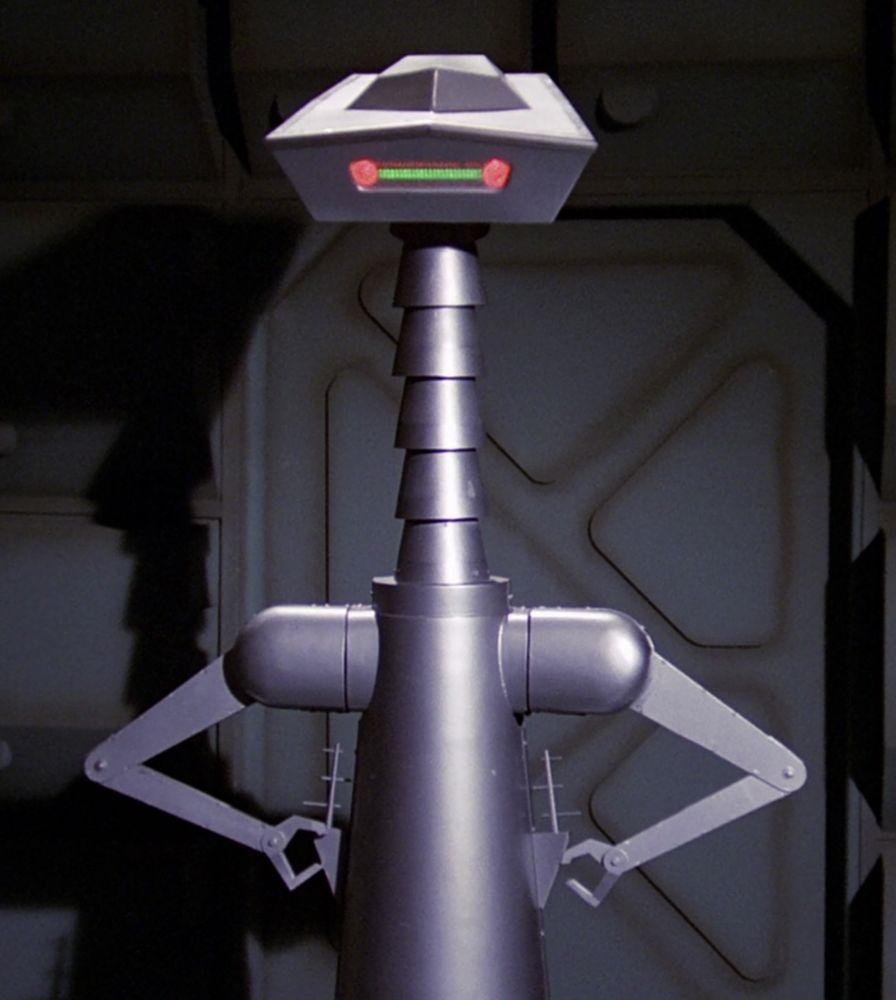 The robot Crichton from BUCK ROGERS IN THE 25TH CENTURY dishing attitude as usual, with his neck fully extended and his claws on his, uh, hips.