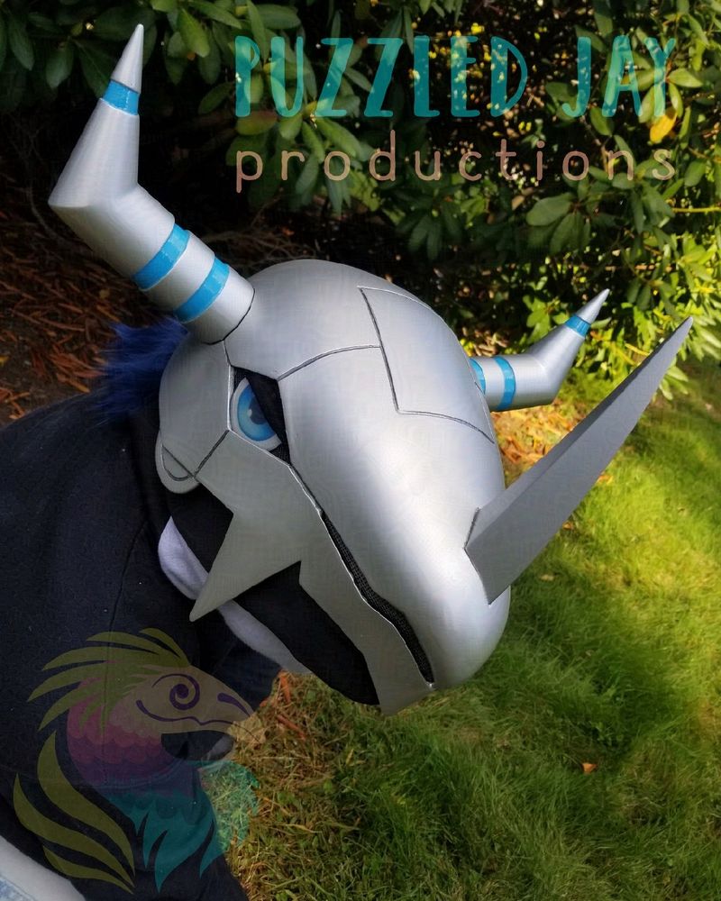 A wargreymon (digimon) helmet against a green nature background