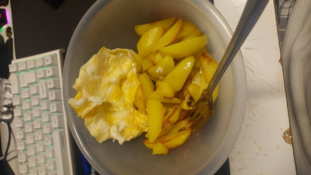 its just bowl of himemade fries with a fried egg in the bowl on the table. the image is very random and seem to resemle the chaos and lack of cohersion between different mediums of author's communication