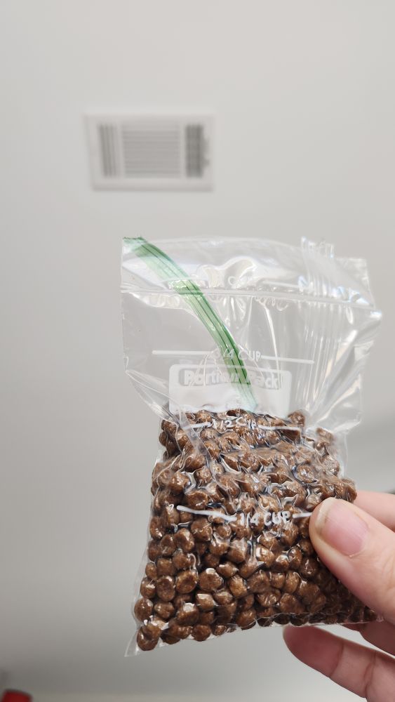 half a cup of cat food vacuum sealed in a small Ziploc bag 