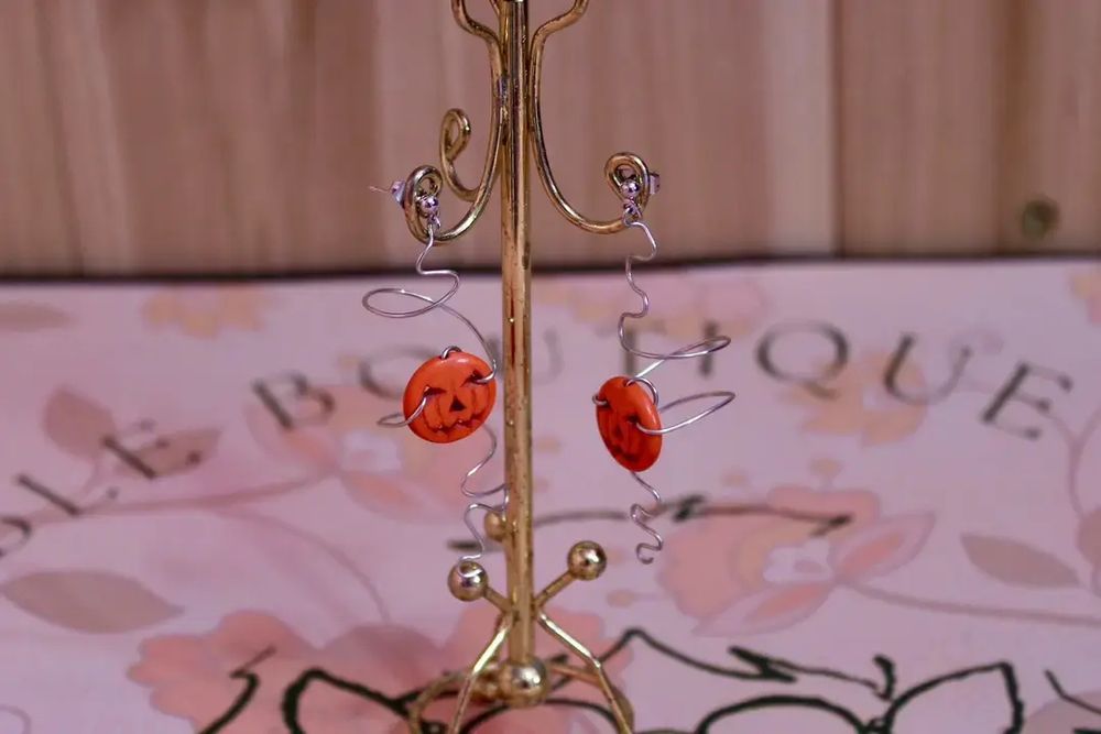Silver spiral earrings with jack-o'-lanterns.