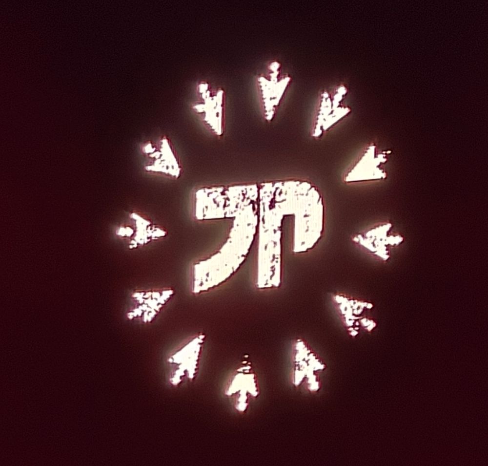 A logo meant to look like the letters "JP" but in a mangled variation of katakana, with a bunch of mouse pointers surrounding it in a circle