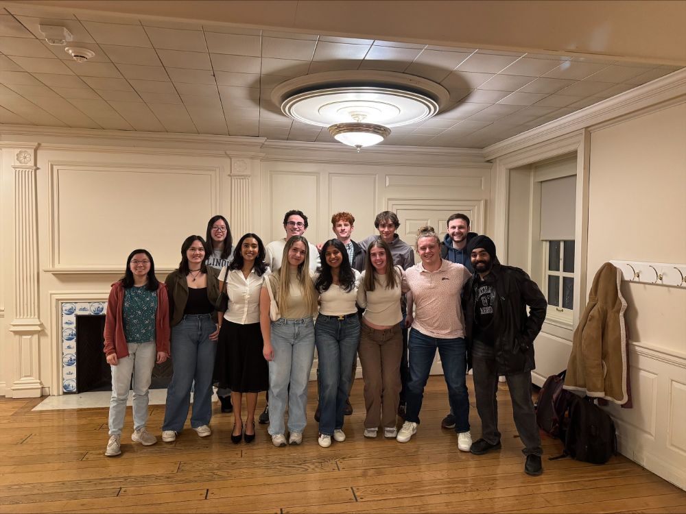 A large group of Chemical Engineering seniors pose together in the corner of a room. 