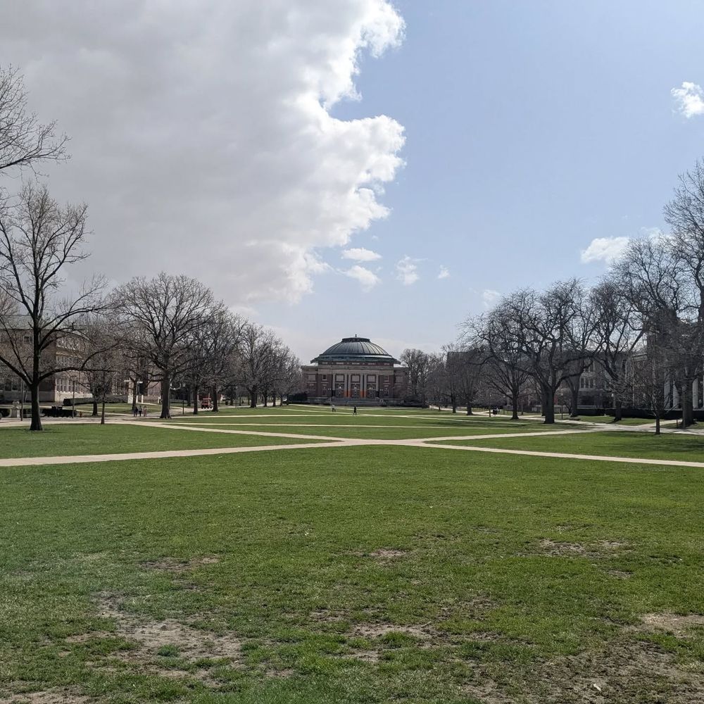 Empty grassy quad with Follinger Auditorium in the center. 