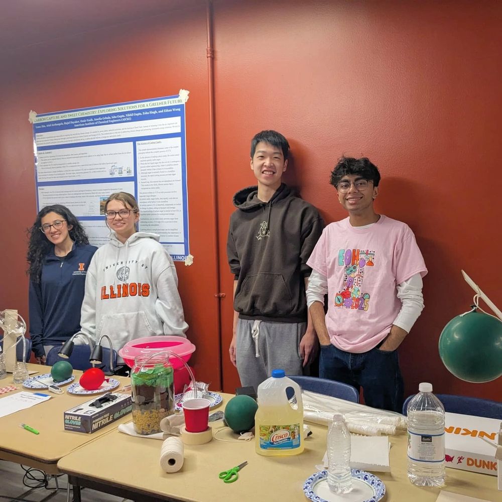 American Institute of Chemical Engineering members pose with their booth "Carbon Capture and Sweet Chemistry".