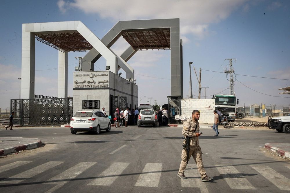 The image shows the Rafah Crossing Point — Gaza’s main gateway to Egypt — under guard, with vehicles and civilians waiting near the entrance. The crossing, a critical lifeline for aid, medical evacuations, and displaced civilians, now faces further restriction amid the deepening humanitarian crisis.