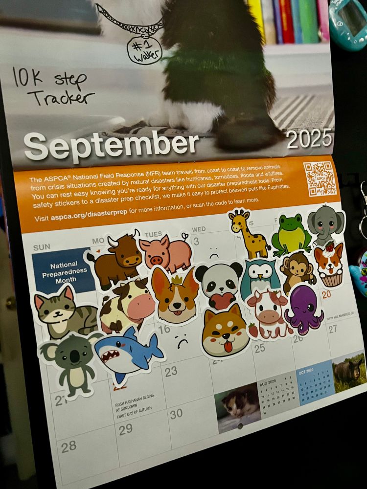 Close image of a calendar. On it are a bunch of animal stickers on the first 19 days. A few days lacking stickers, and there are frowny faces drawn on those days instead.