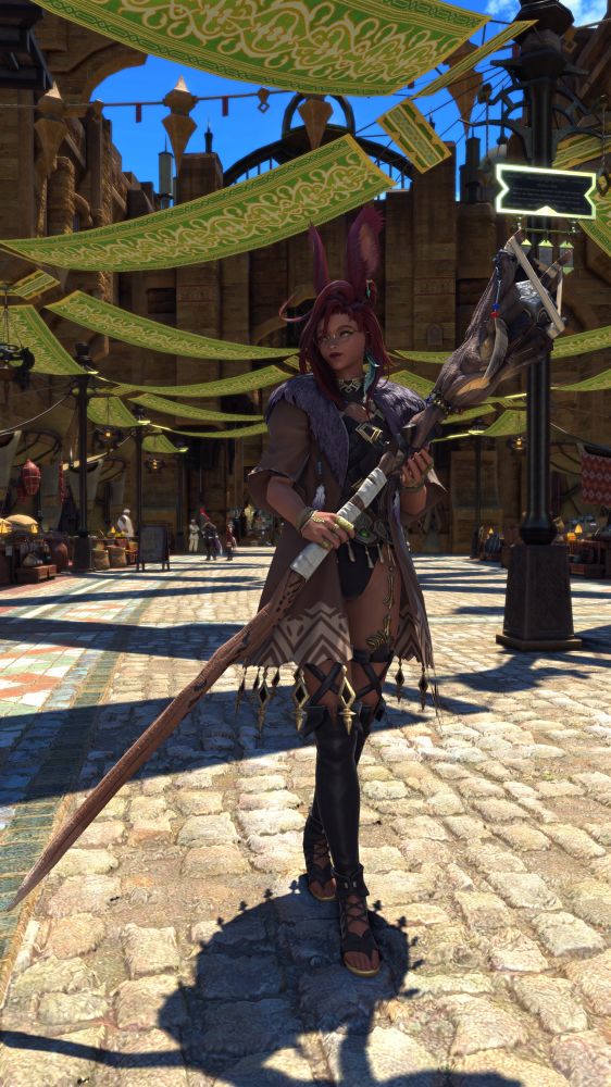 A redheaded viera woman walks through the streets of a busy market, holding her staff.