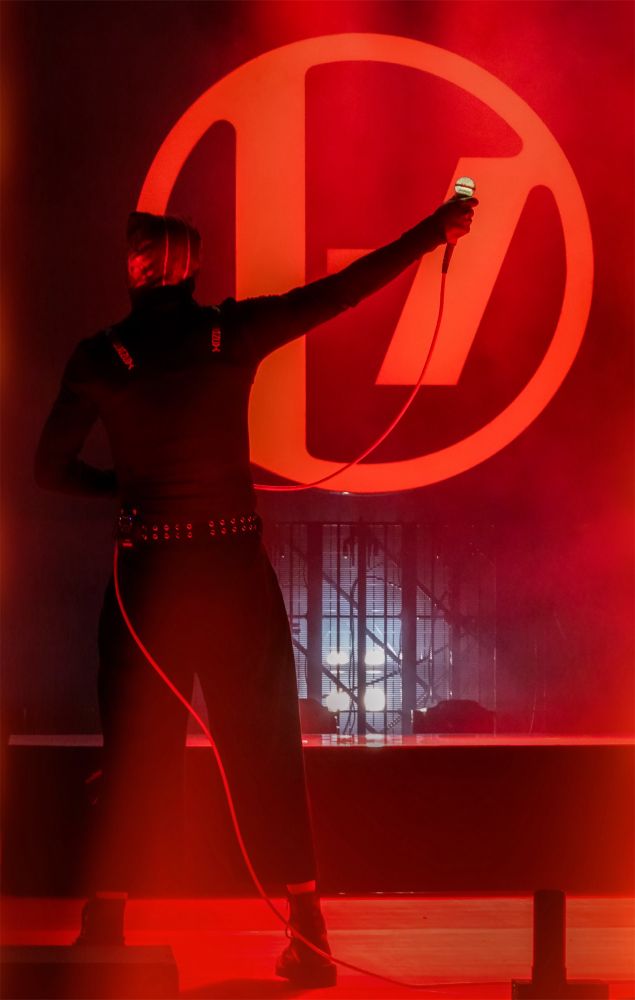 Photo is of Tyler during overcompensate. His back is to the camera and his right arm is raised and holding the light up microphone. 