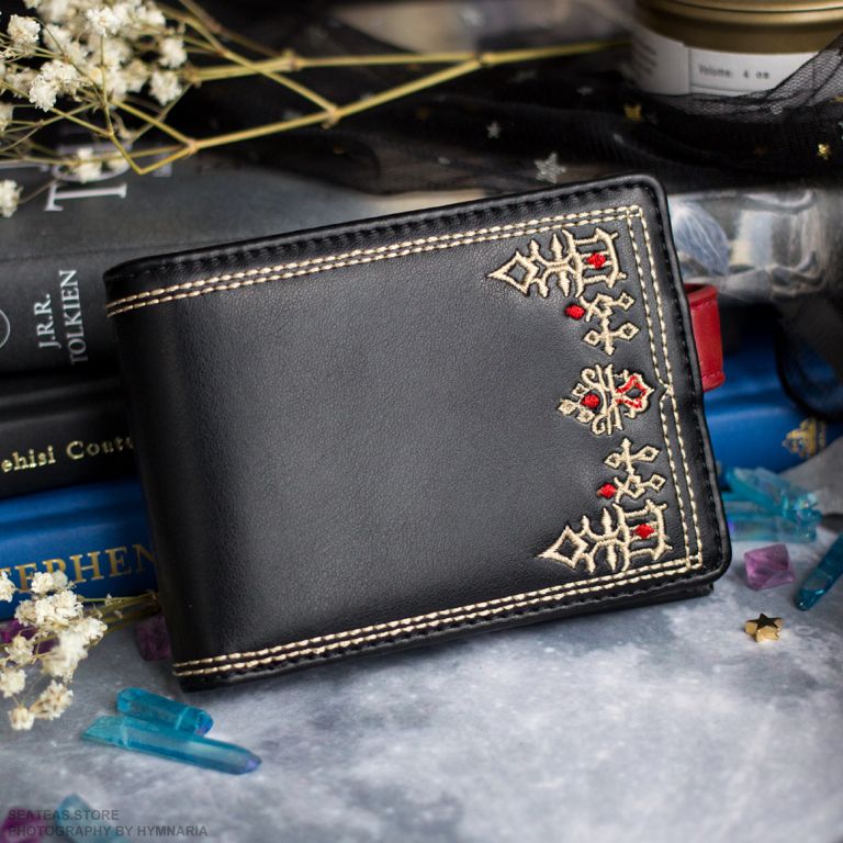 Black bifold wallet with G'raha Tia's shirt pattern embroidered on the front.