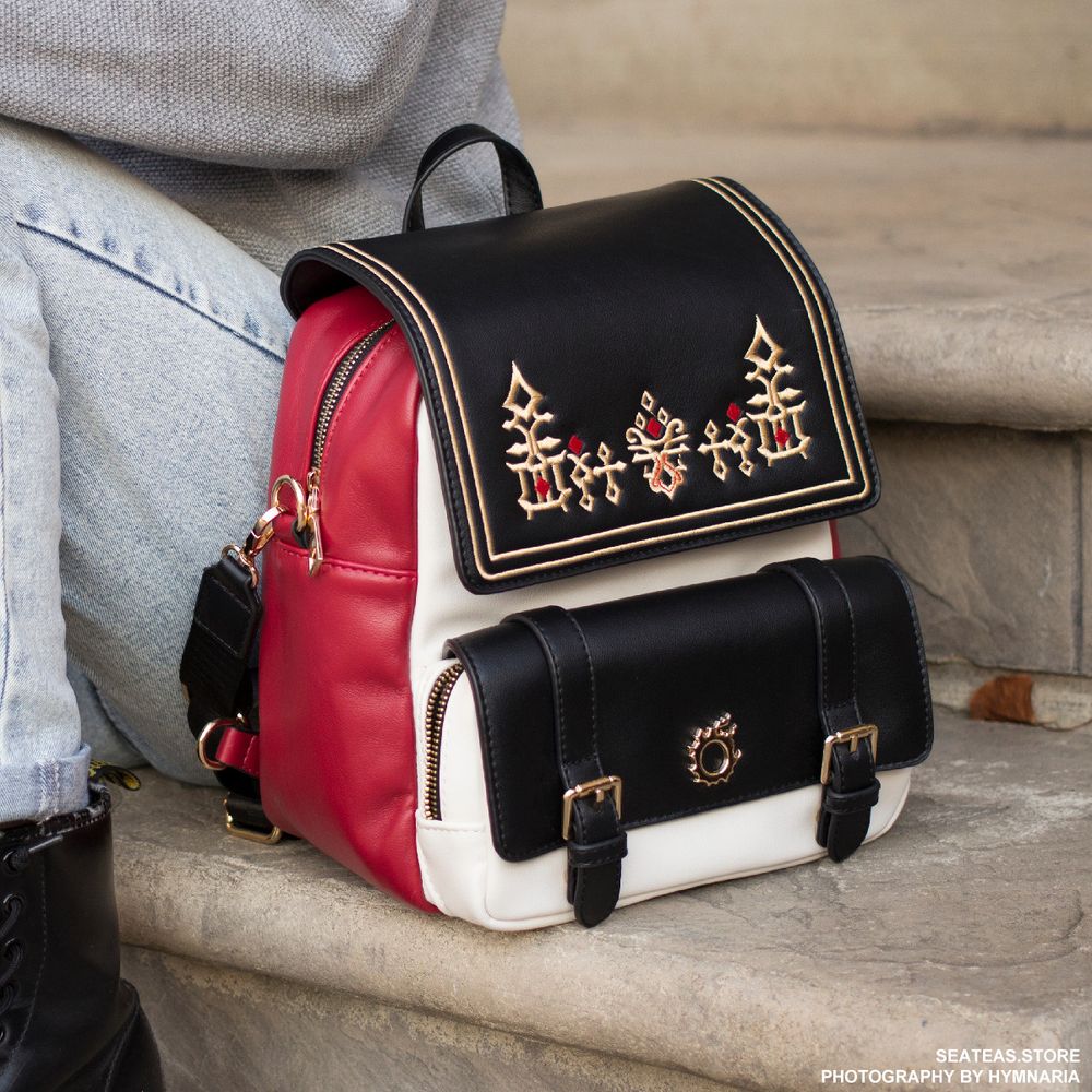 A backpack that can be transformed into a bag. It has G'raha Tia's shirt design embroidered on the front with gold hardware of the Meteor icon. 