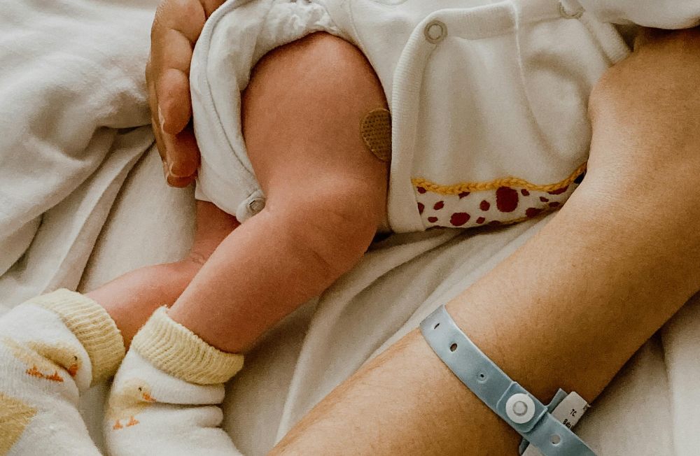 newborn in mother's arms post vaccine