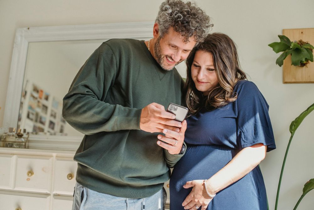pregnant couple using smartphone app