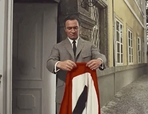 Christopher Plummer, playing Captain von Trapp in the Sound of Music, rips a Nazi flag.