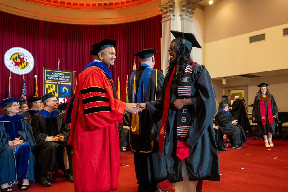 Dean Amitabh Varshney shaking a graduate's hand at the 2024 Graduate Commencement Ceremony