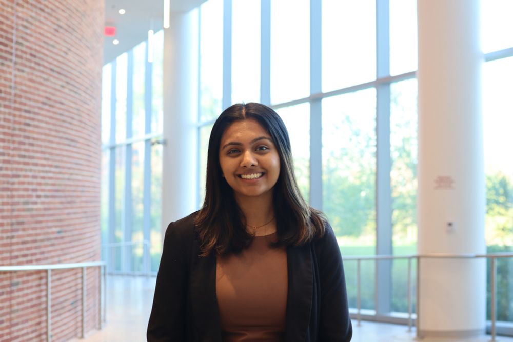 Sharvari Tirodkar wearing a blazer and standing in front of the windows in the Iribe Center lobby