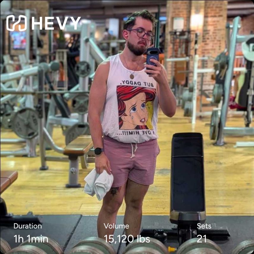 Gym mirror selfie of me in my little mermaid tank and pink shorts. Hevy workout info included 