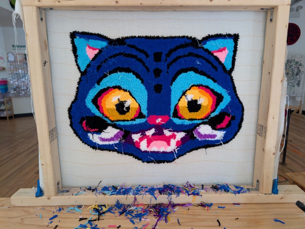 Canvas full of tufting yarn of Derpy the tiger from Kpop Demon Hunters. 