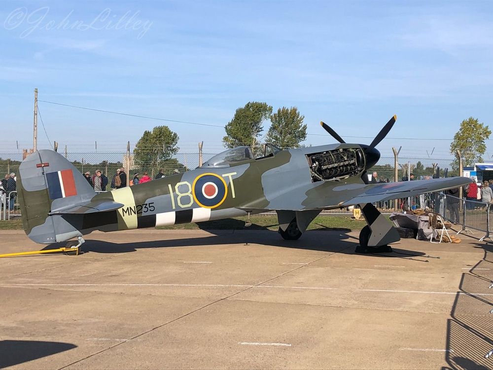 Hawker Typhoon, WW2 fighter-bomber, on display in the sunshine at RAF Coningsby, the home of the RAF's Battle of Britain Memorial Flight. Normally displayed in the RAF Museum, it was loaned to Canada for a time, as Canadian Squadrons had played a part in the Normandy invasion in 1944. It was displayed at the Canada Air & Space Museum in 2014 in the markings of 440 Sqn, RCAF. The engine cowlings are removed to show the Napier Sabre 24 cylinder sleeve-valve engine. MN235 was never issued to the RAF and was sent to the USA for testing. 