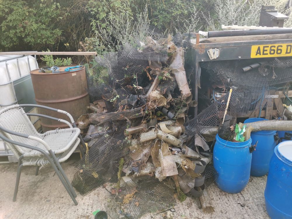 A large pile of plastic tree guards, dating to when Home Wood was planted some decades ago and now long past their useful life. 