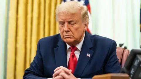Donald Trump pretends to pray, probably to a demon
